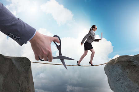 Hand cutting the rope under businesswoman tightrope walkerの写真素材