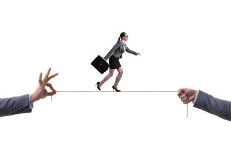 Businesswoman walking on tight rope in business conceptの写真素材