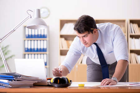 Engineer supervisor working on drawings in the officeの写真素材