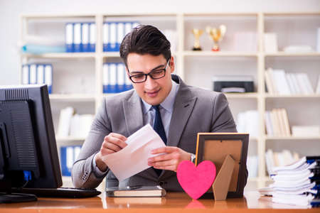 Businessman in saint valentine concept in officeの写真素材