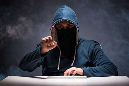 Computer hacker working in dark roomの写真素材