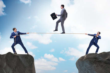 Businessman walking on tight rop in business concept