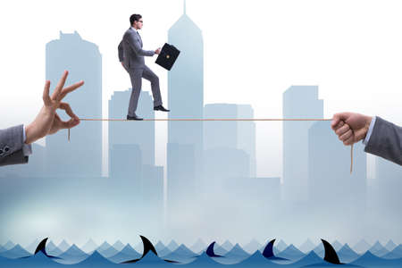 Businessman walking on tight rop in business conceptの写真素材