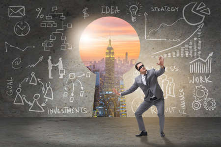 Businessman lost in front of giant keyholeの写真素材