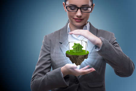Businesswoman holding flying island in eco conceptの写真素材