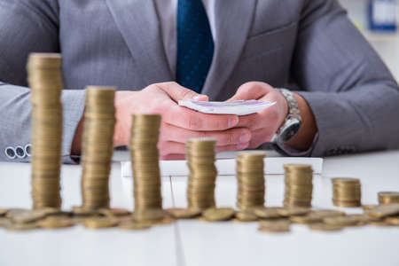 Businessman with golden coins in business growth conceptの写真素材