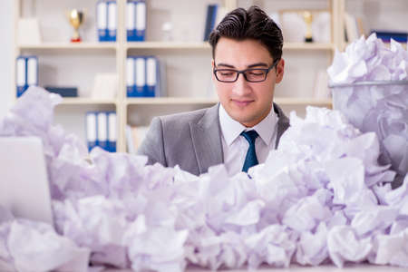 Businessman in paper recycling concept in officeの写真素材