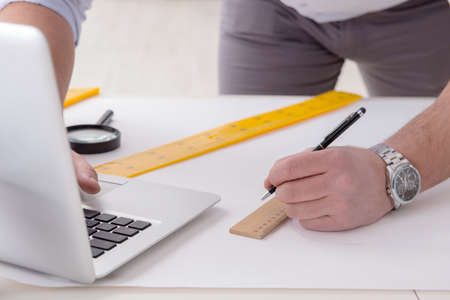 Male engineer working on drawings and blueprintsの写真素材