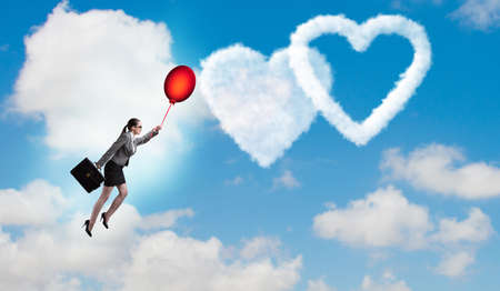 Woman flying balloons in romantic conceptの写真素材