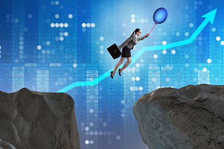 Businesswoman flying holding balloonの写真素材