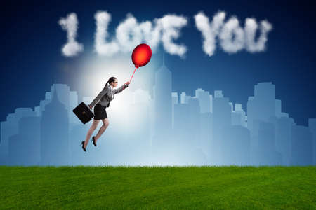Woman flying balloons in romantic conceptの写真素材