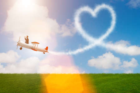 Man flying airplane and making heart shape