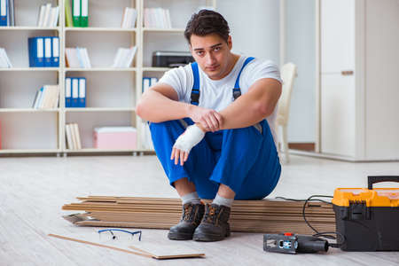 Young worker working on floor laminate tilesの写真素材