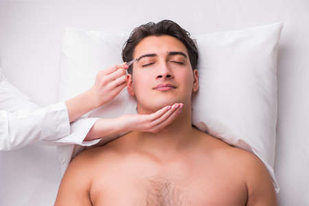 Handsome man in spa massage conceptの写真素材