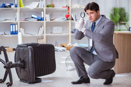 Young man during crime investigation in officeの写真素材