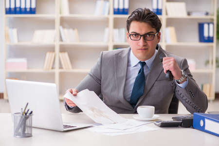 Businessman spilling coffee on important documentsの写真素材