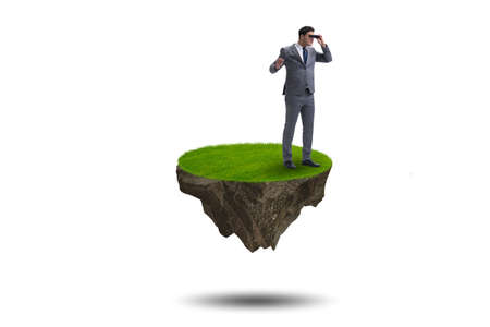 Businessman on flying island with binocularsの写真素材