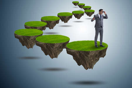 Businessman on flying island with binocularsの写真素材