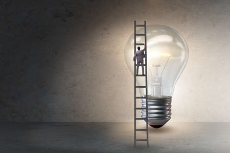 Businessman on ladder with light bulbの写真素材