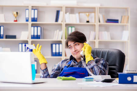 Male cleaner working in the officeの写真素材