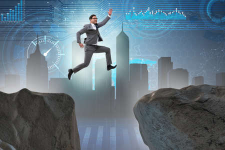 Ambitious businessman jumping over the cliffの写真素材