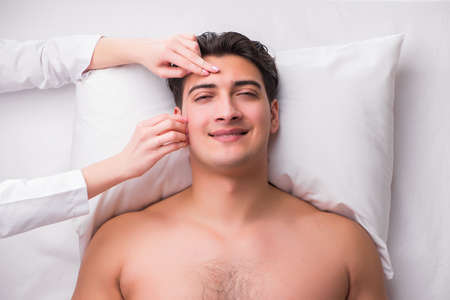 Handsome man in spa massage conceptの写真素材