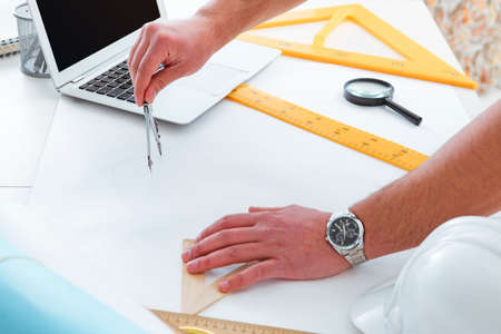 Male engineer working on drawings and blueprintsの写真素材