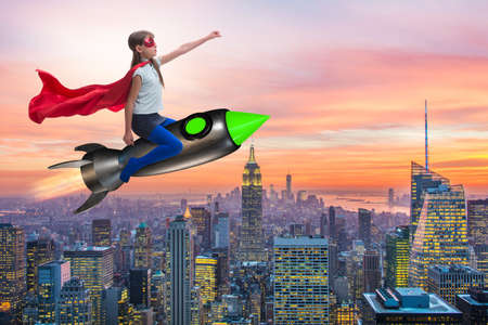 Little girl flying rocket in superhero conceptの写真素材