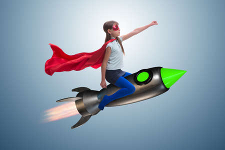 Little girl flying rocket in superhero conceptの写真素材