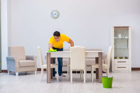 Young man doing chores at homeの写真素材