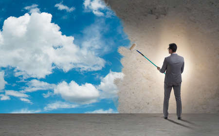 Businessman painting sky and cloudsの写真素材