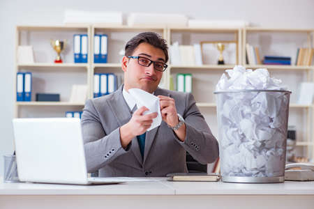 Businessman in paper recycling concept in officeの写真素材