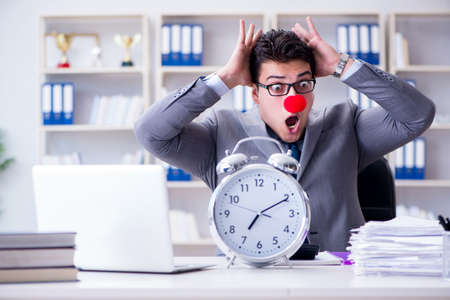 Clown businessman with alarm clock missing dieadlineの写真素材