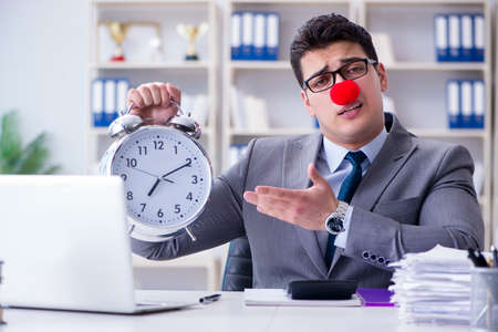 Clown businessman with alarm clock missing dieadlineの写真素材