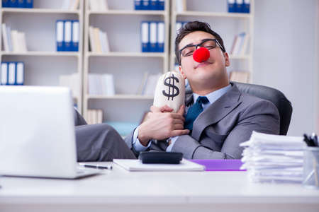 Clown businessman in the office with the a money sackの写真素材