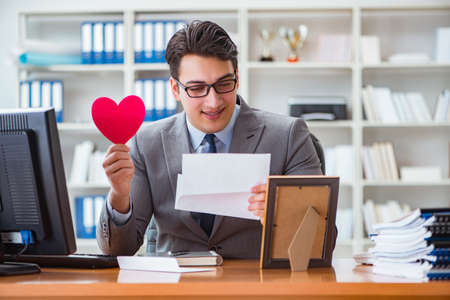 Businessman in saint valentine concept in officeの写真素材