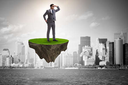 Businessman on flying island looking into futureの写真素材