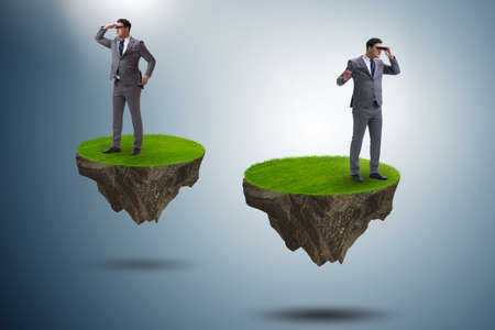 Businessman on flying island with binocularsの写真素材