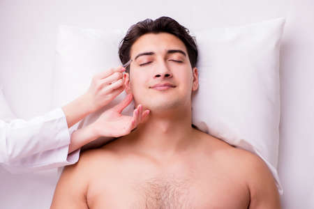 Handsome man in spa massage conceptの写真素材