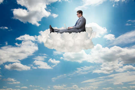 Businessman working on laptop in the skyの写真素材