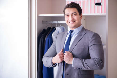 Young man businessman getting dressed for workの写真素材