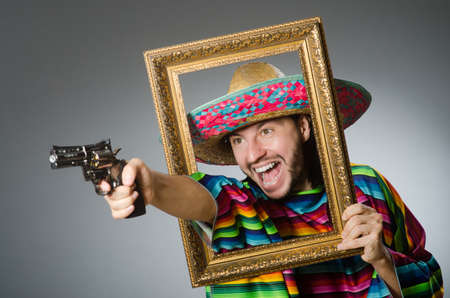 Man in a vivid mexican poncho gray background isolatedの写真素材