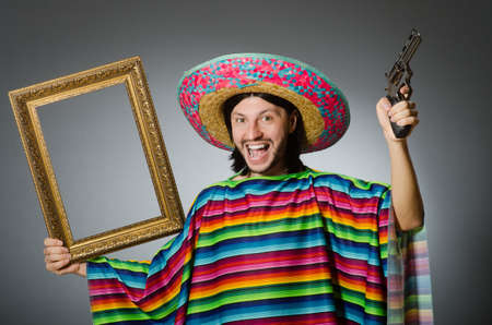 Man in a vivid mexican poncho gray background isolatedの写真素材