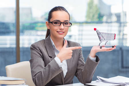 Businesswoman with small shopping cartの写真素材