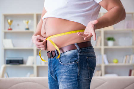 Man suffering from extra weight in diet conceptの写真素材