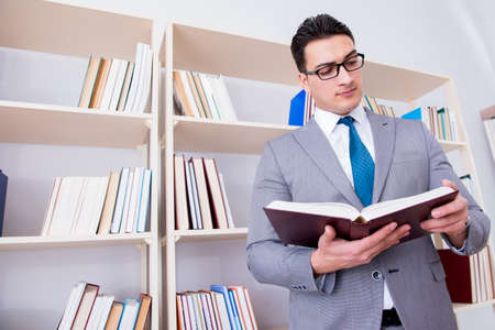 Businessman student reading a book studying in libraryの写真素材