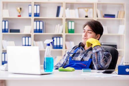 Male cleaner working in the officeの写真素材