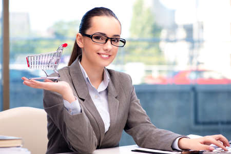 Businesswoman with small shopping cartの写真素材