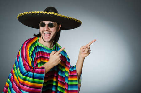 Man in a vivid mexican poncho gray background isolatedの写真素材
