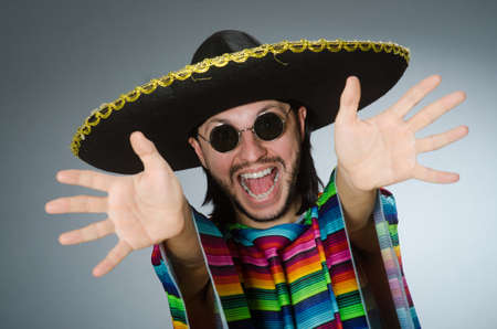 Man in a vivid mexican poncho gray background isolatedの写真素材